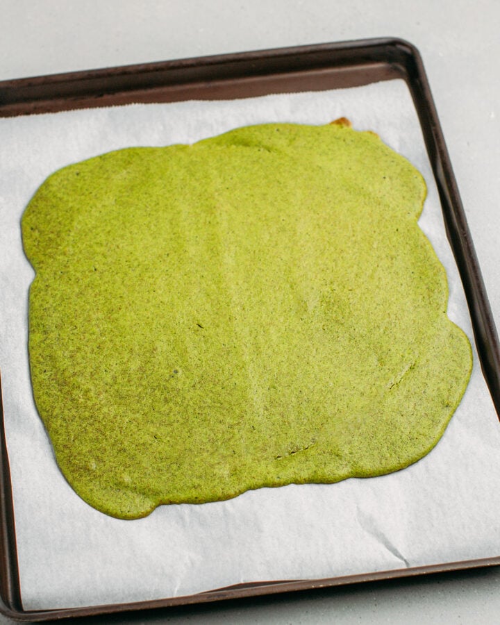 Baked matcha sponge cake on a baking sheet.
