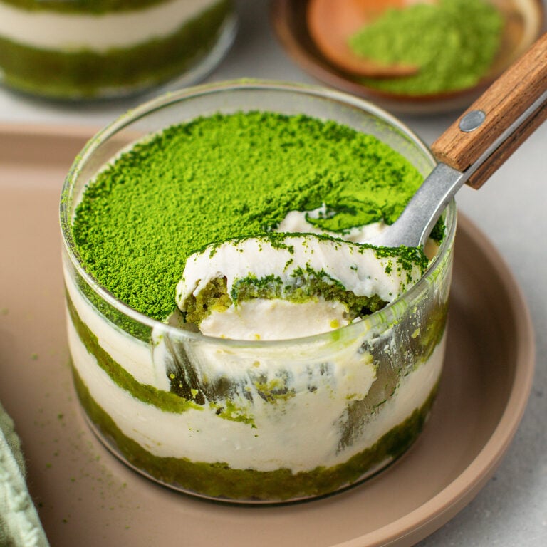 Matcha tiramisu in a glass ramekin.