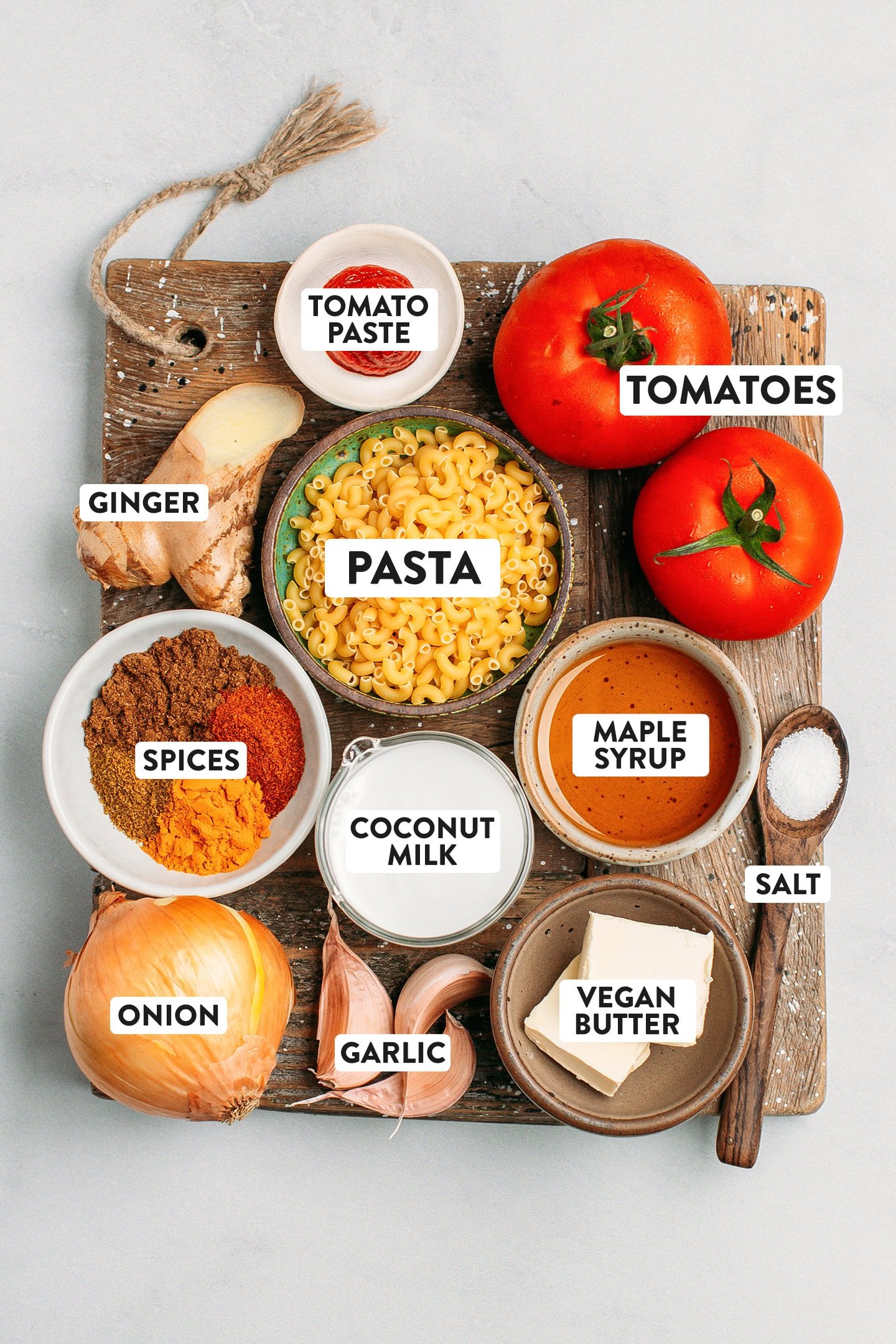 Ingredients like pasta, tomatoes, onion, garlic, ginger, and coconut milk.