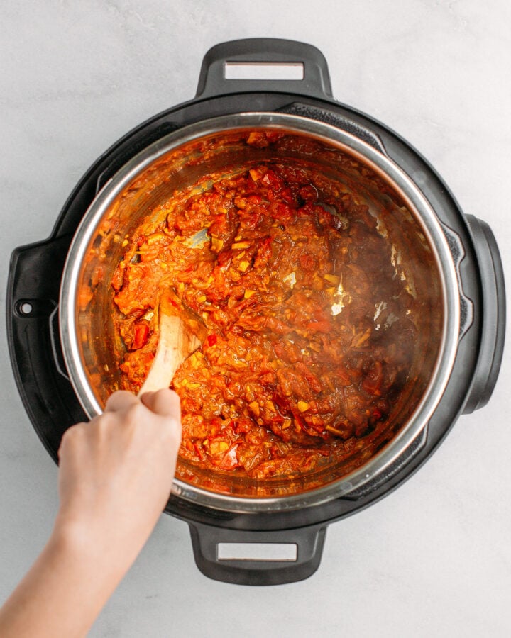 Stirring homemade tomato sauce in an Instant Pot.