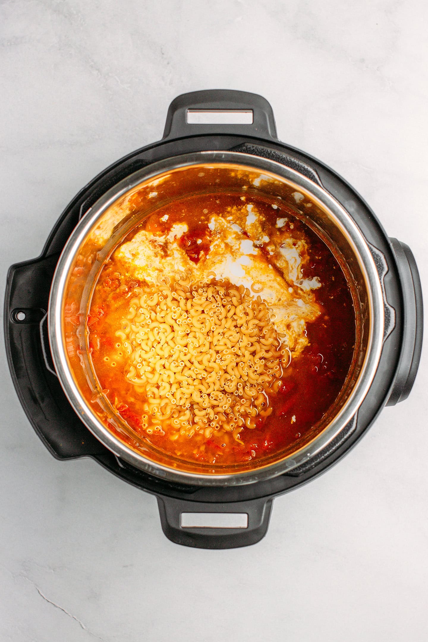 Dry macaroni pasta with tomato sauce and coconut milk in an Instant Pot.