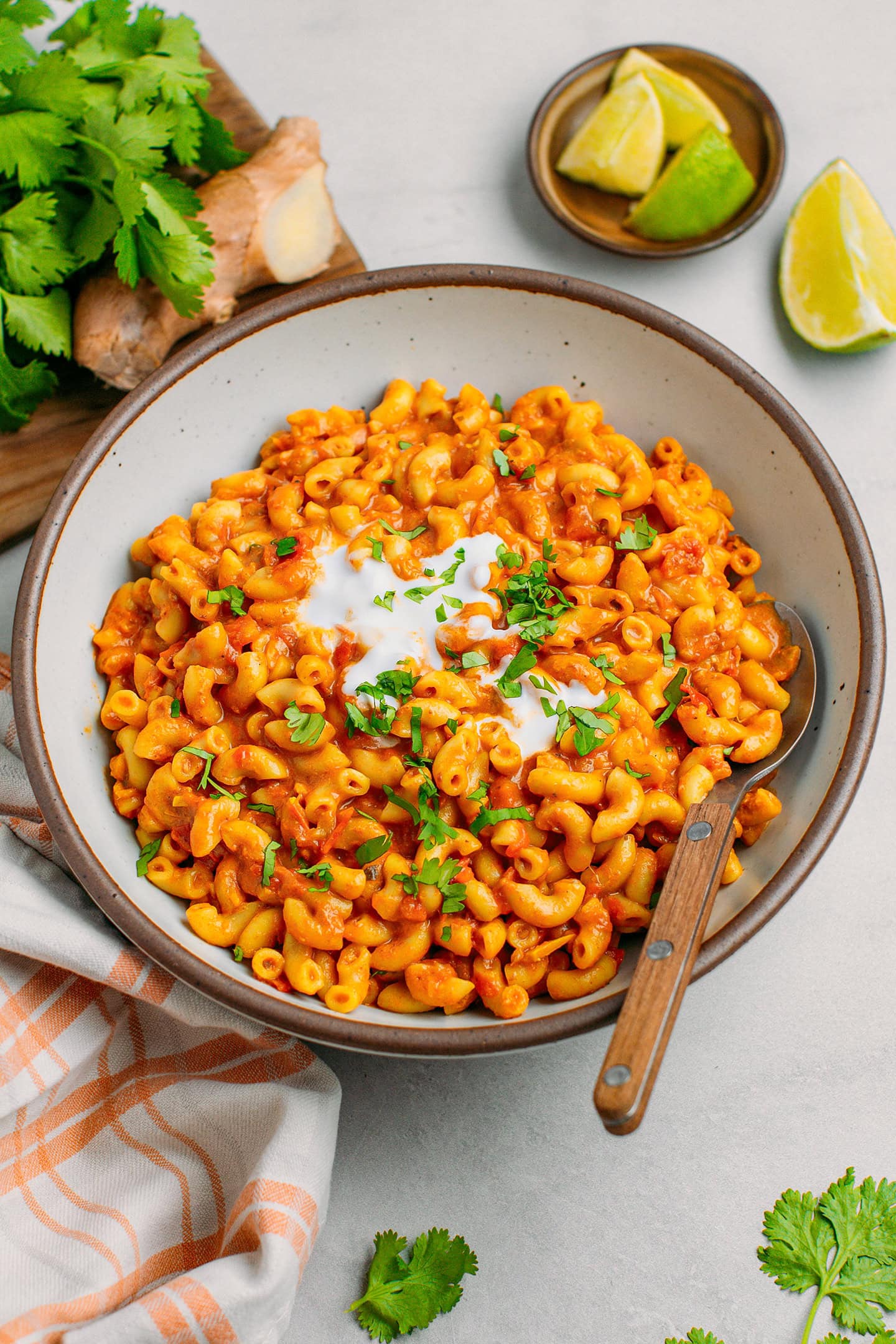 Tikka masala macaroni topped with coconut cream and chopped cilantro in a bowl.