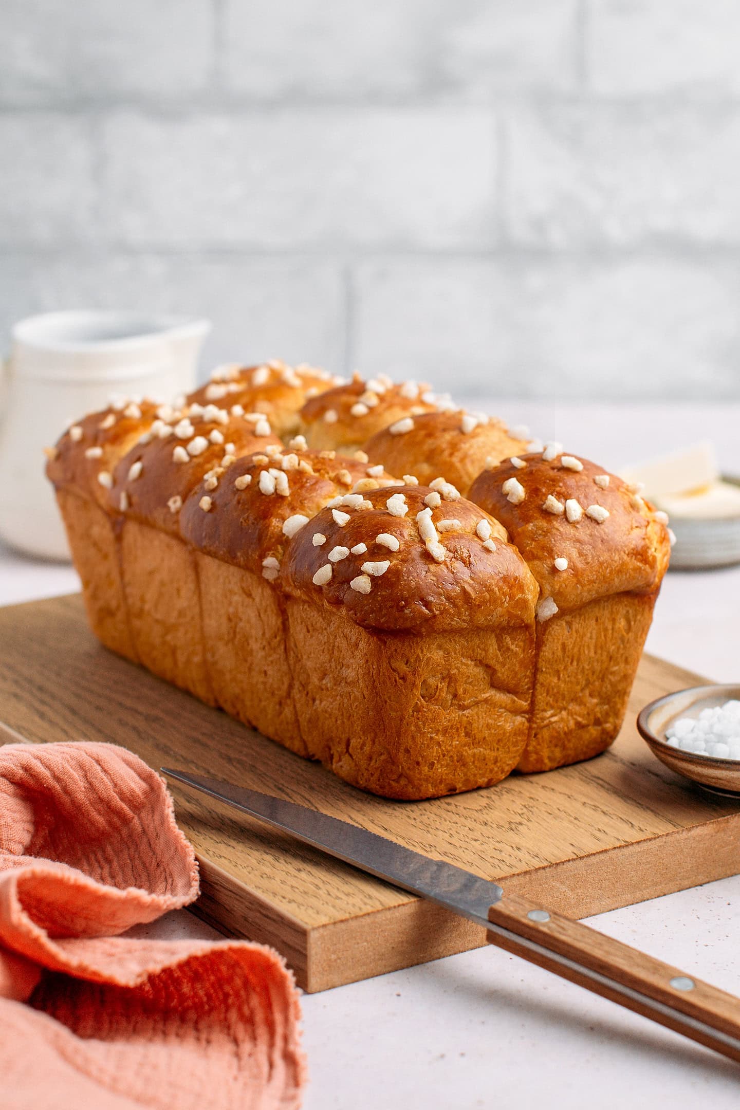Whole loaf of vegan brioche on a wood cutting board.