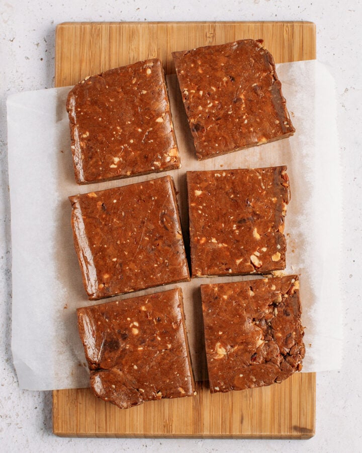 6 rectangle protein bars on a wood cutting board.