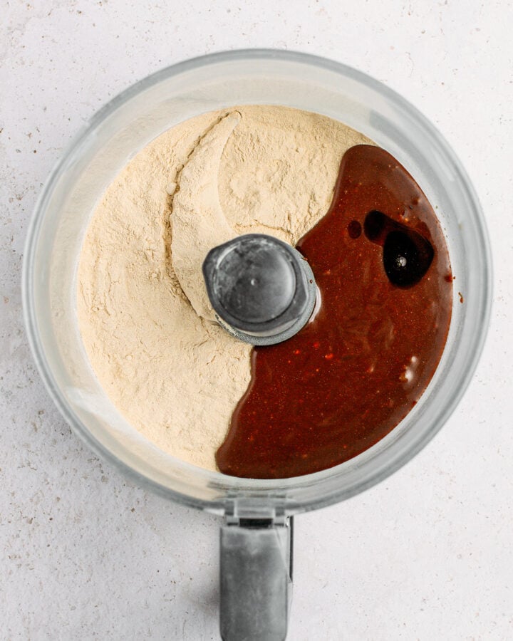Protein powder, coconut nectar, and almond butter in a food processor.