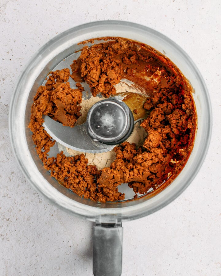 Protein powder combined with coconut nectar and almond butter in a food processor.