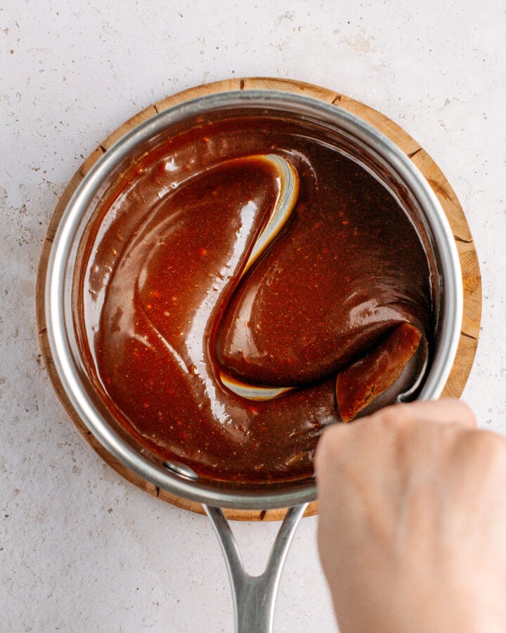 Stirring almond butter and coconut nectar in a saucepan.