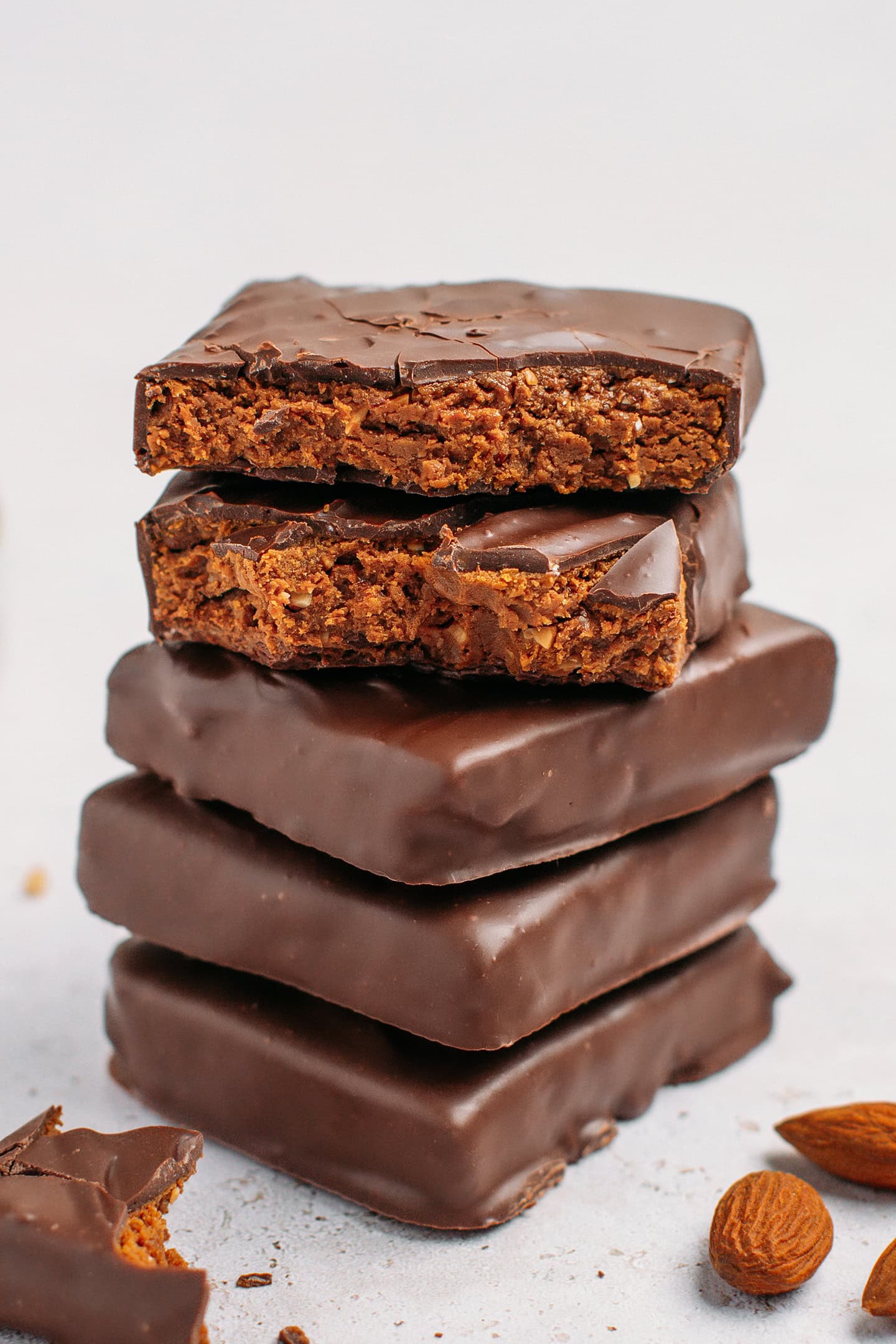 Five chocolate-coated protein bars stacked.
