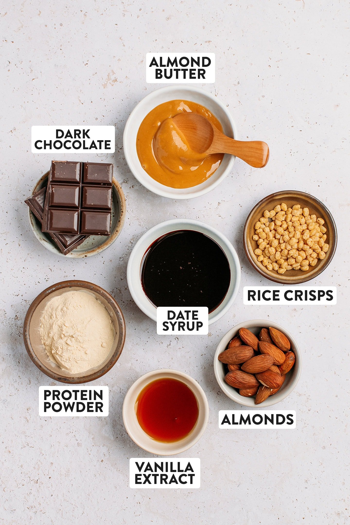 Ingredients like protein powder, date syrup, almond butter, and dark chocolate.