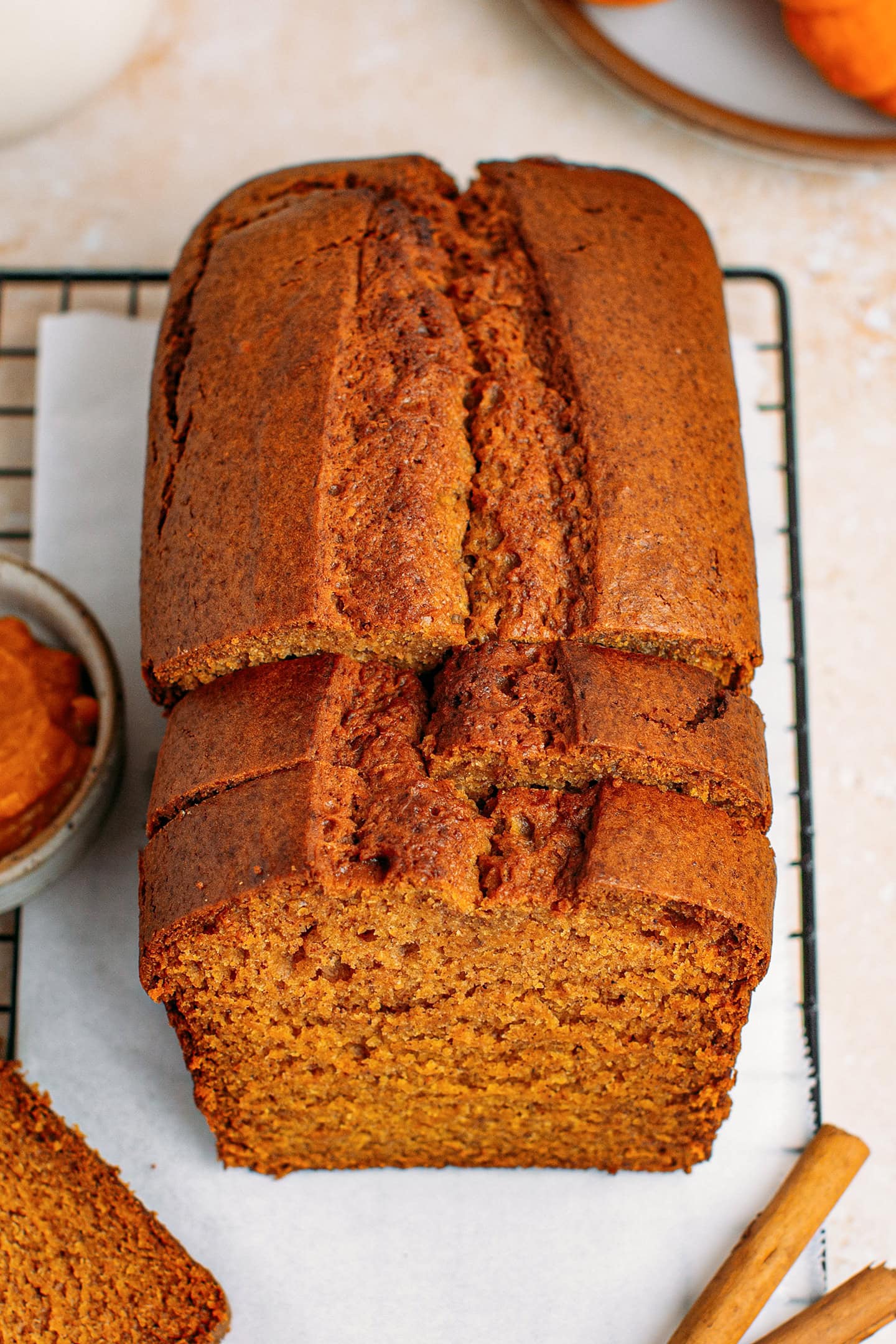 Top view of a sliced vegan pumpkin bread on a layer of parchment paper.
