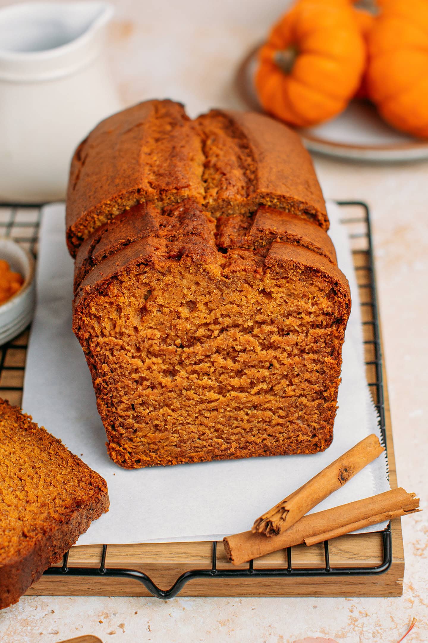 Pumpkin bread on a cooling rack with mini pumpkins in the background.