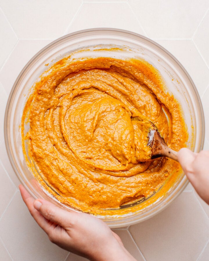 Mixing pumpkin cake batter in a bowl.