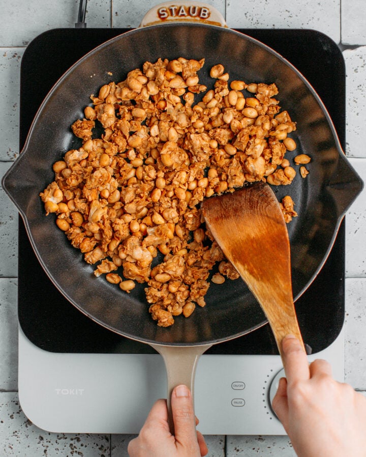 Cooking scrambled tempeh in a skillet.