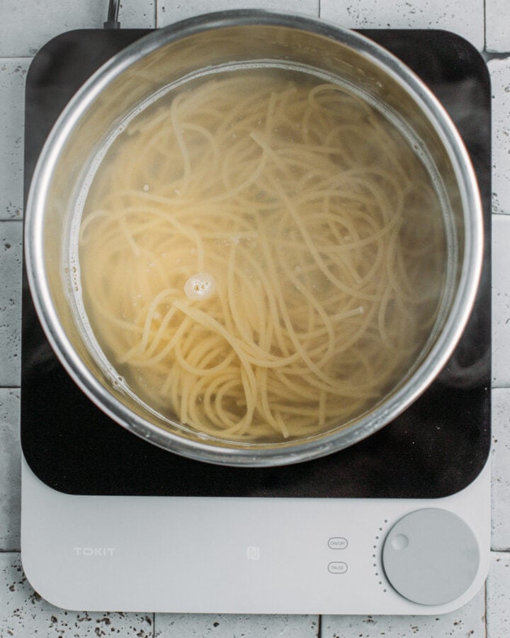 Noodles cooking in a pot of water.