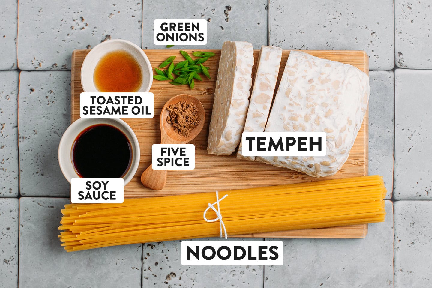Ingredients like tempeh, toasted sesame oil, soy sauce, and noodles.