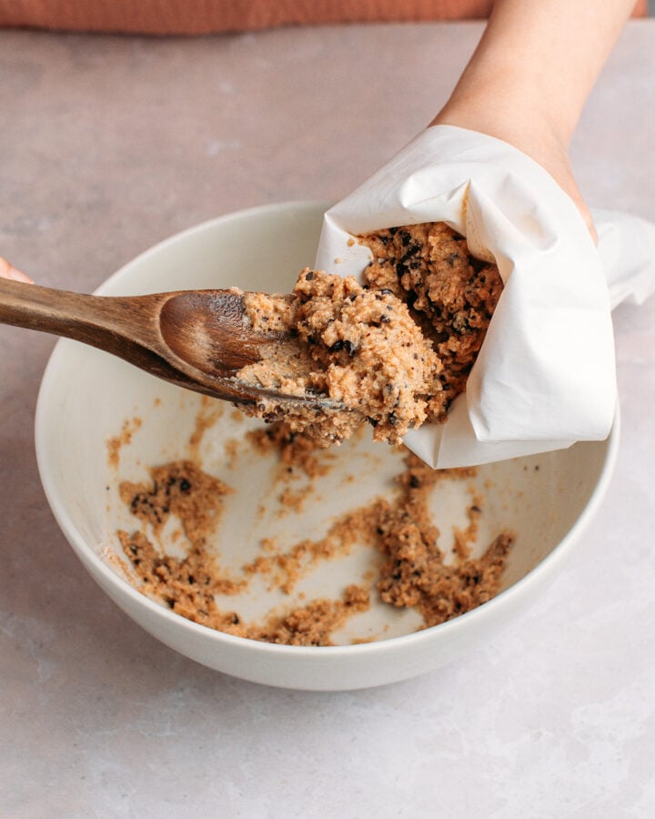 Transferring chocolate chip cereal batter to a piping bag.
