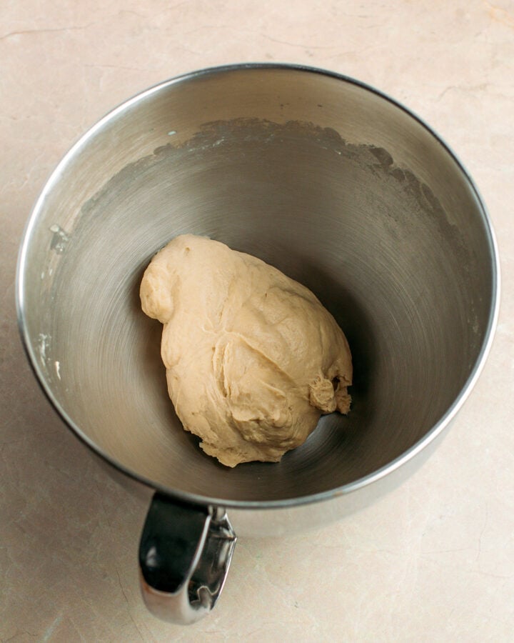 Ball of dough in a stand mixer bowl.