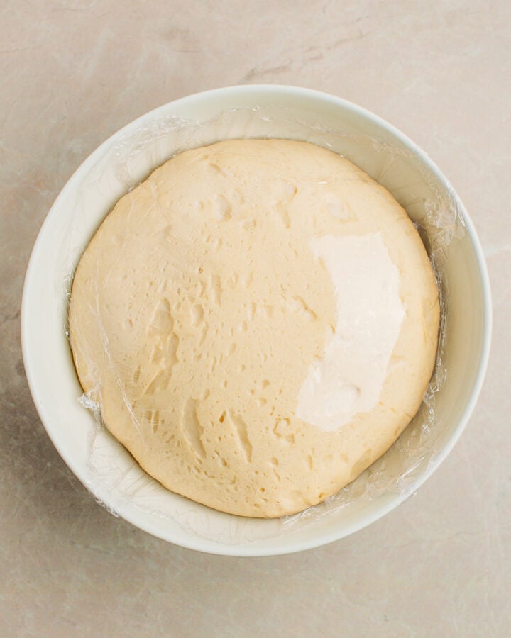 Brioche dough, after rising, in a mixing bowl.