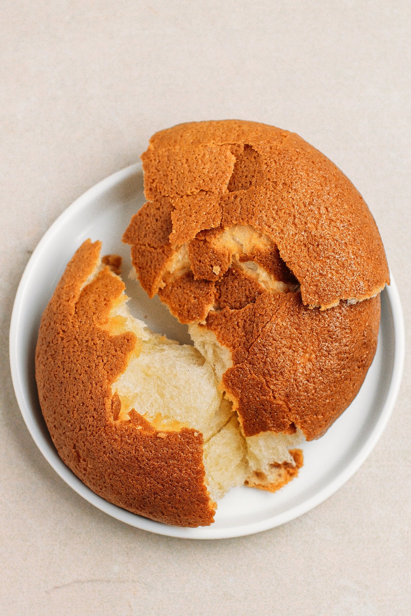 Top view of a Papparoti bun on a small white plate.