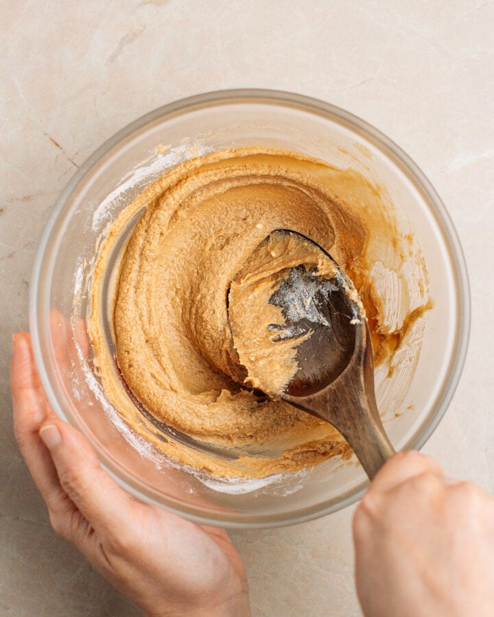 Mixing creamed butter with coffee and flour in a small glass bowl.