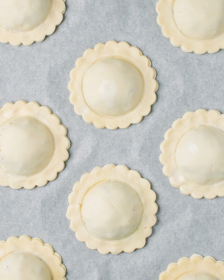 Vegan meat pastries on a baking sheet before baking.