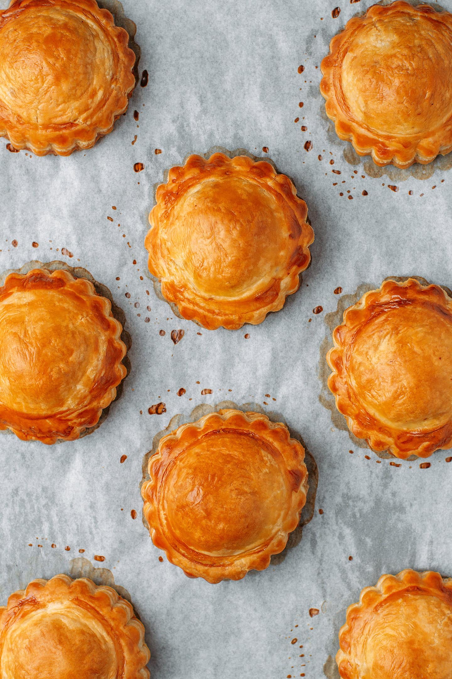 Baked vegan meat pastries on a baking sheet lined with parchment paper.