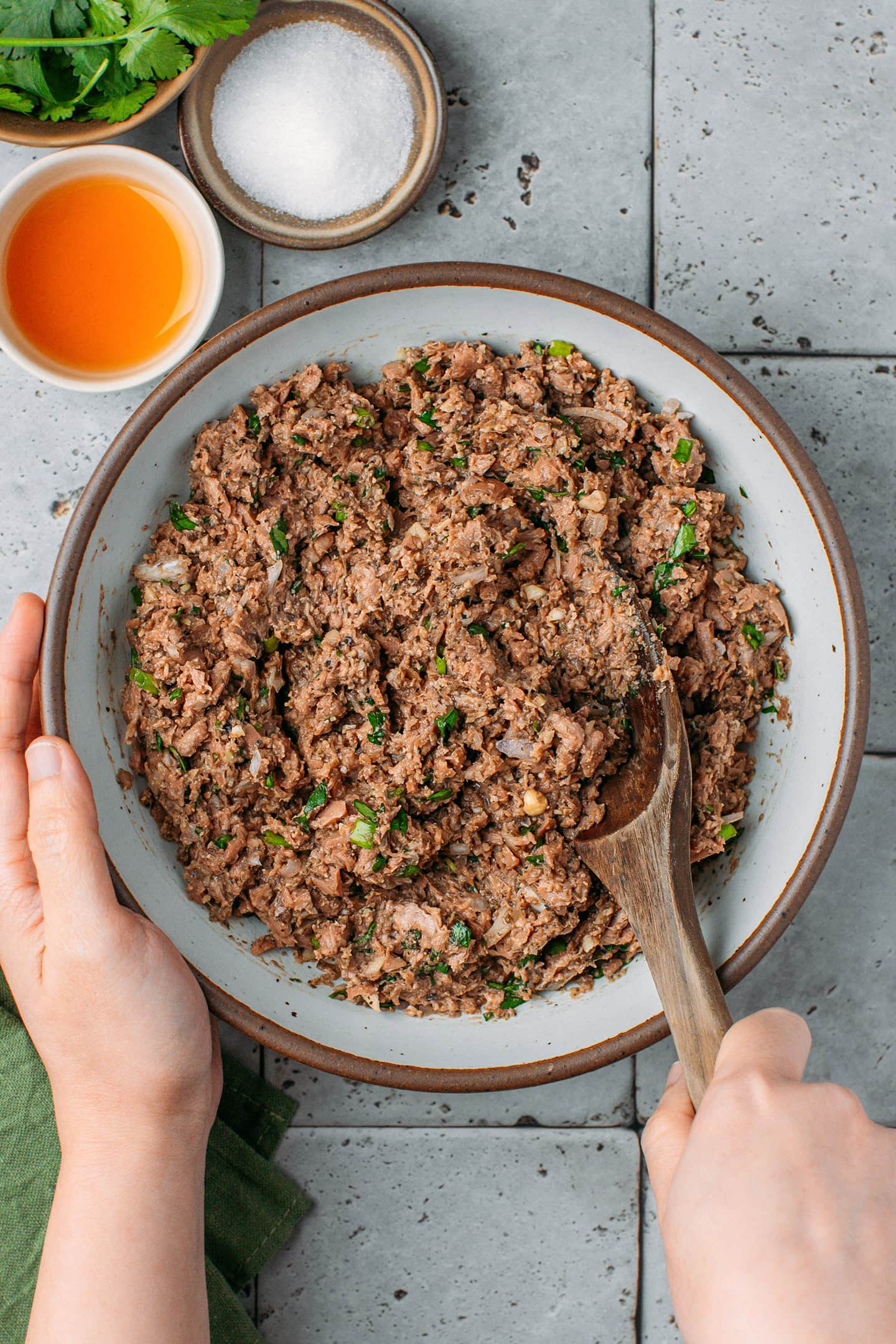 Stirring vegan meat filling in a small bowl.