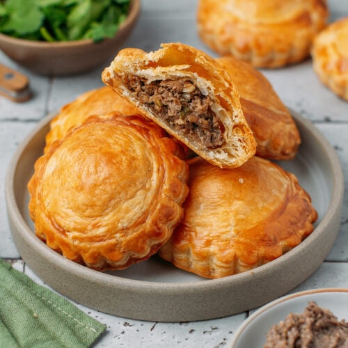 Stacked meat pastries on a small plate.