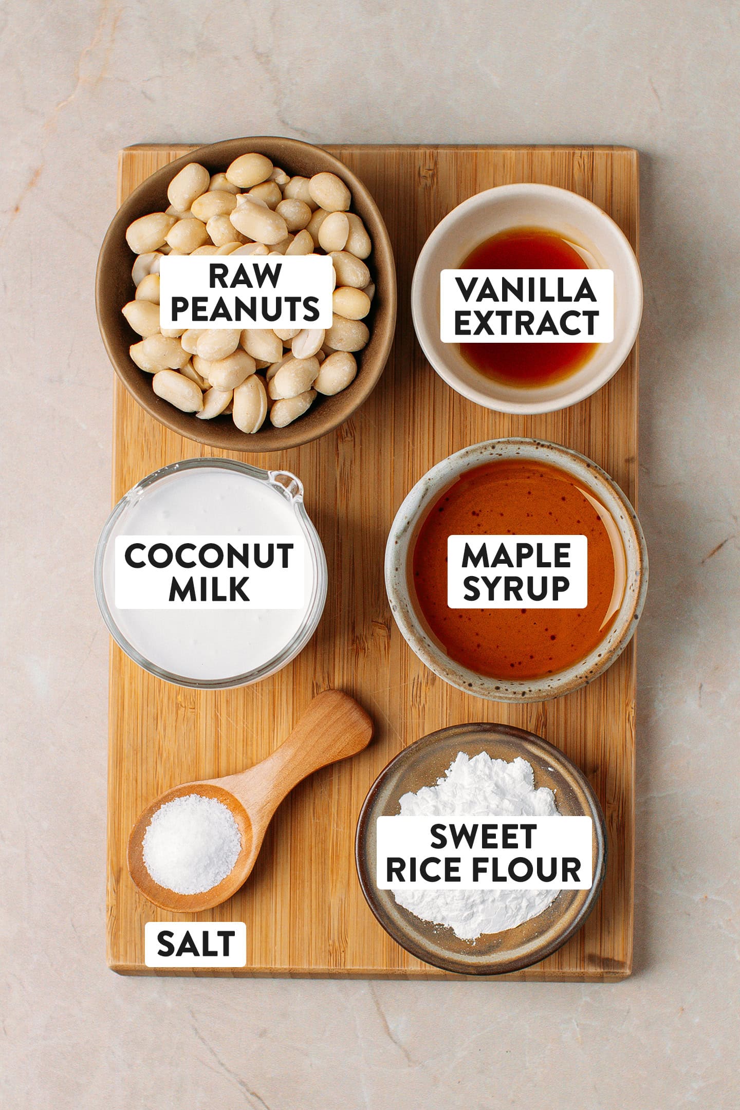 Ingredients like raw peanuts, coconut milk, maple syrup, and vanilla extract.