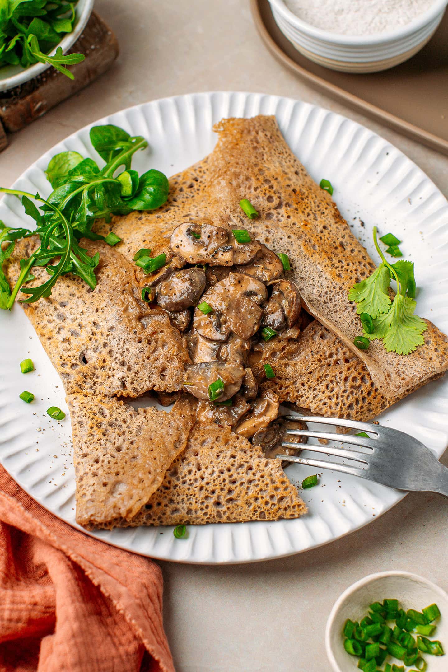 Buckwheat crêpe filled with creamy mushrooms and garnished with chopped green onions.
