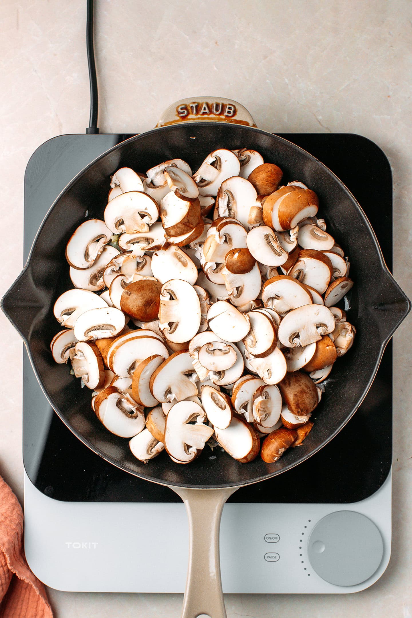 Sliced cremini mushrooms in a skillet.
