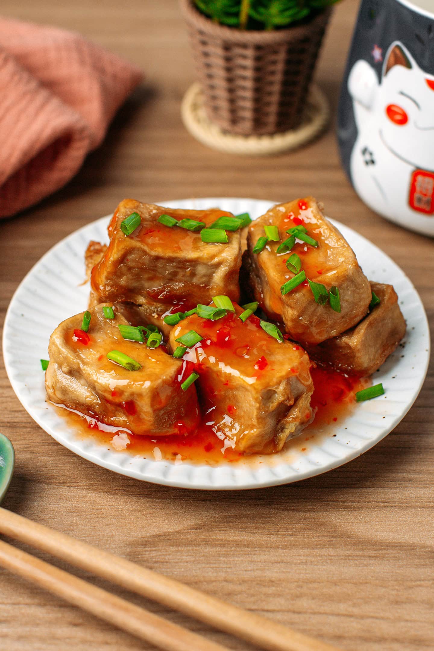 Small plate filled with fried tofu and drizzled with sweet chili sauce.