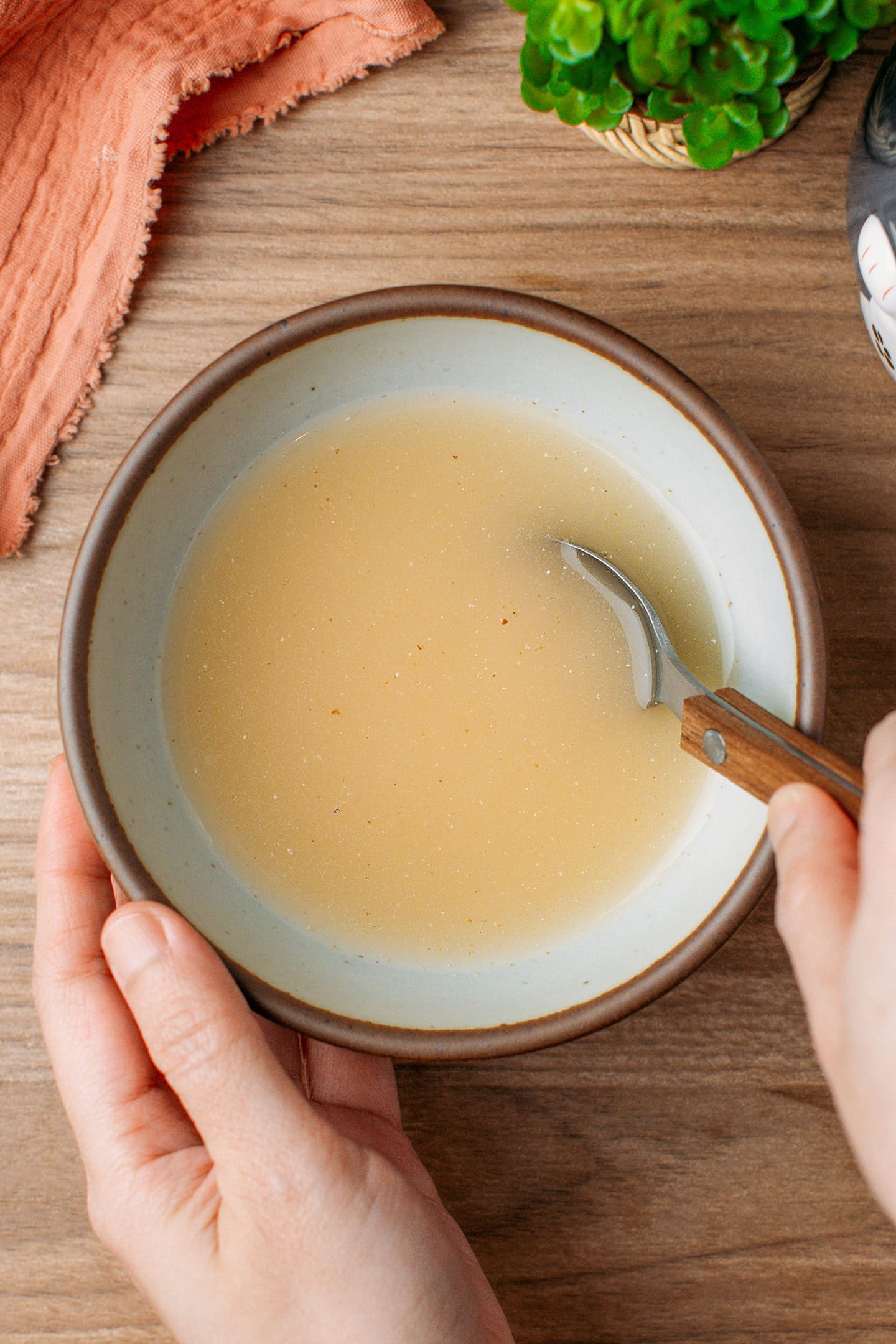 Mixing water and starter powder in a bowl using a spoon.