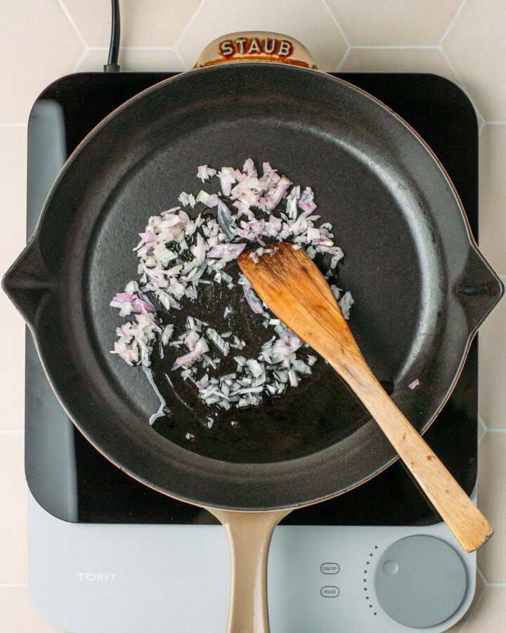 Sautéed minced shallots in a skillet.