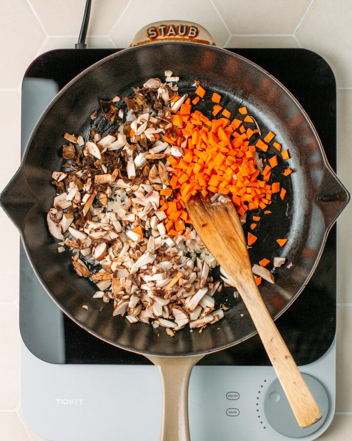 Chopped carrots and mushrooms in a skillet.