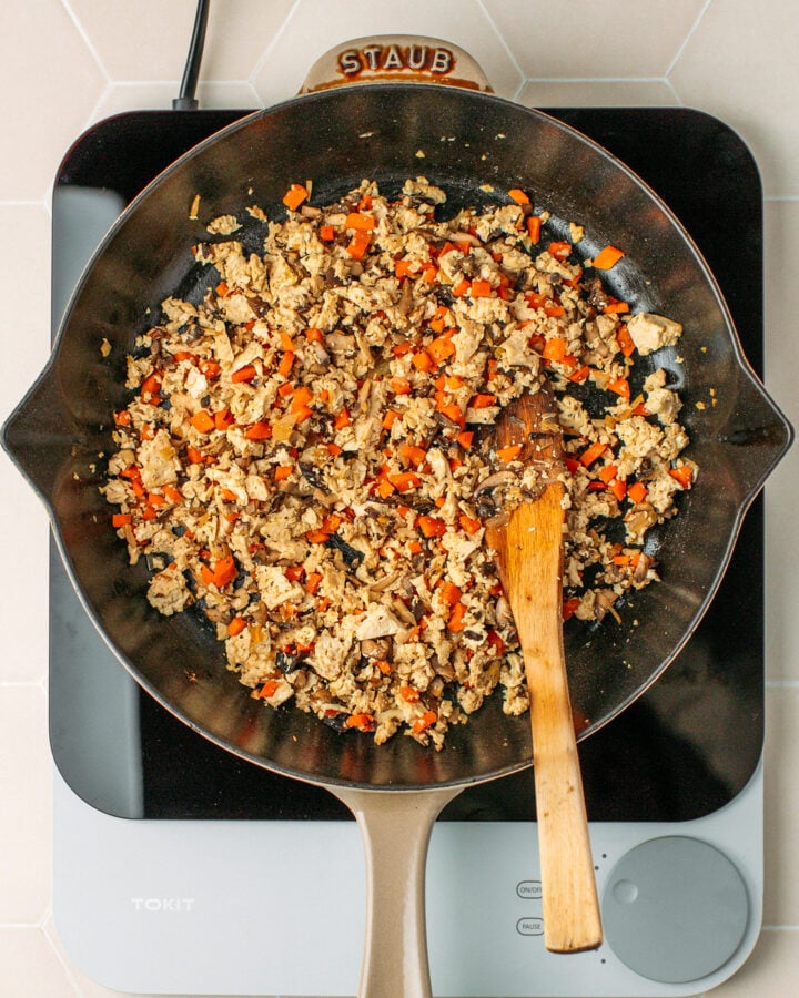Sautéed tofu, carrots, and mushrooms in a skillet.