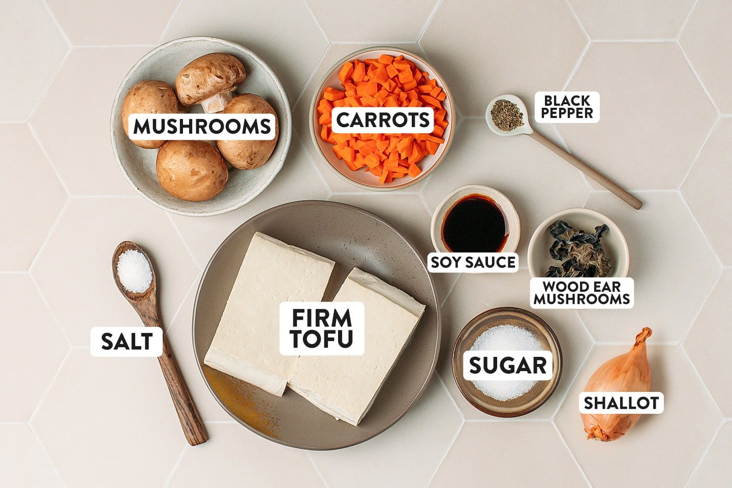 Ingredients like firm tofu, mushrooms, carrots, and shallot.