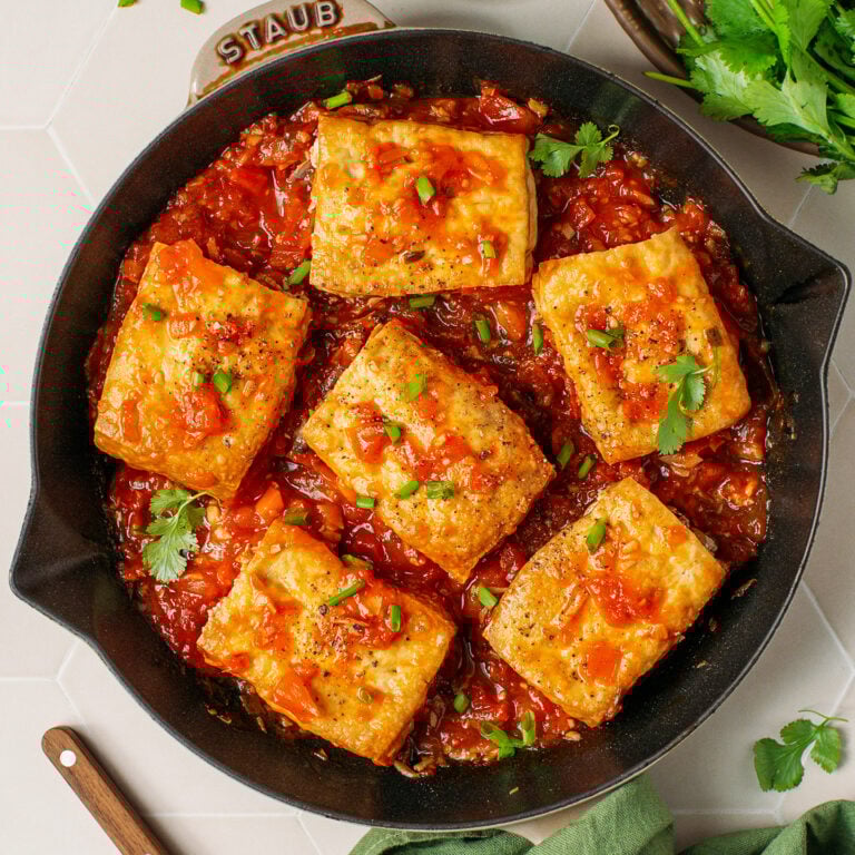 Six pieces of stuffed tofu in tomato sauce.
