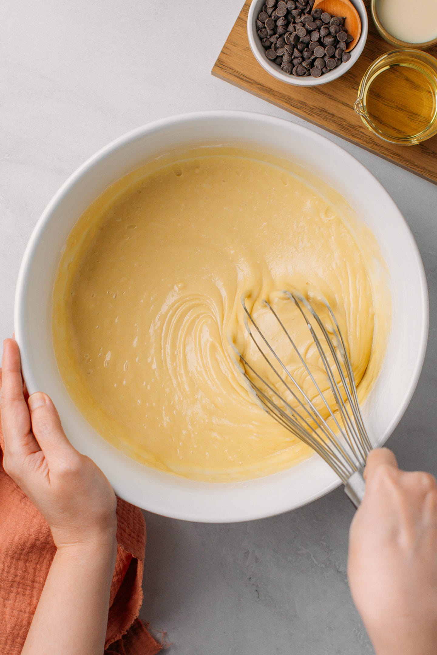 Whisking a loaf cake batter in a mixing bowl.