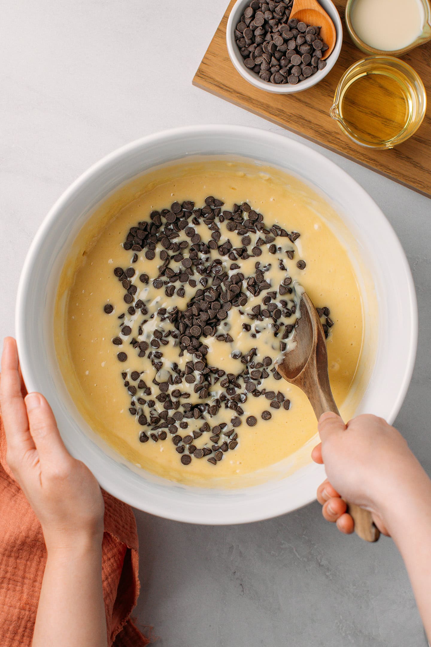 Stirring chocolate chips into a cake batter.