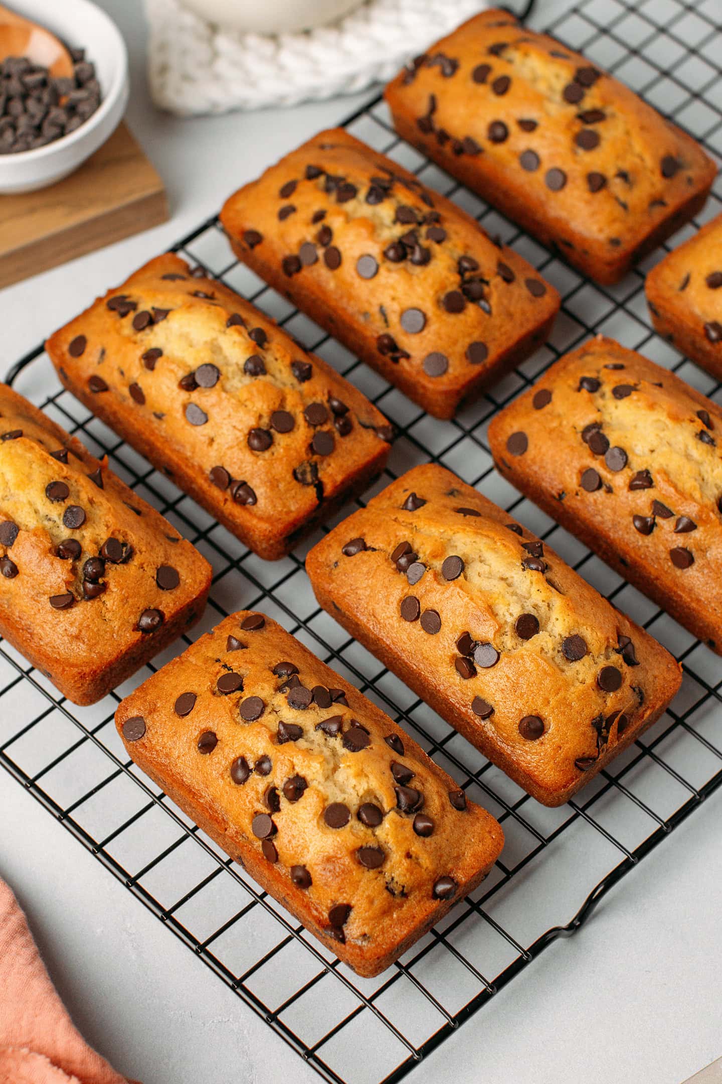 Eight mini chocolate chip loaf cakes on a cooling rack.