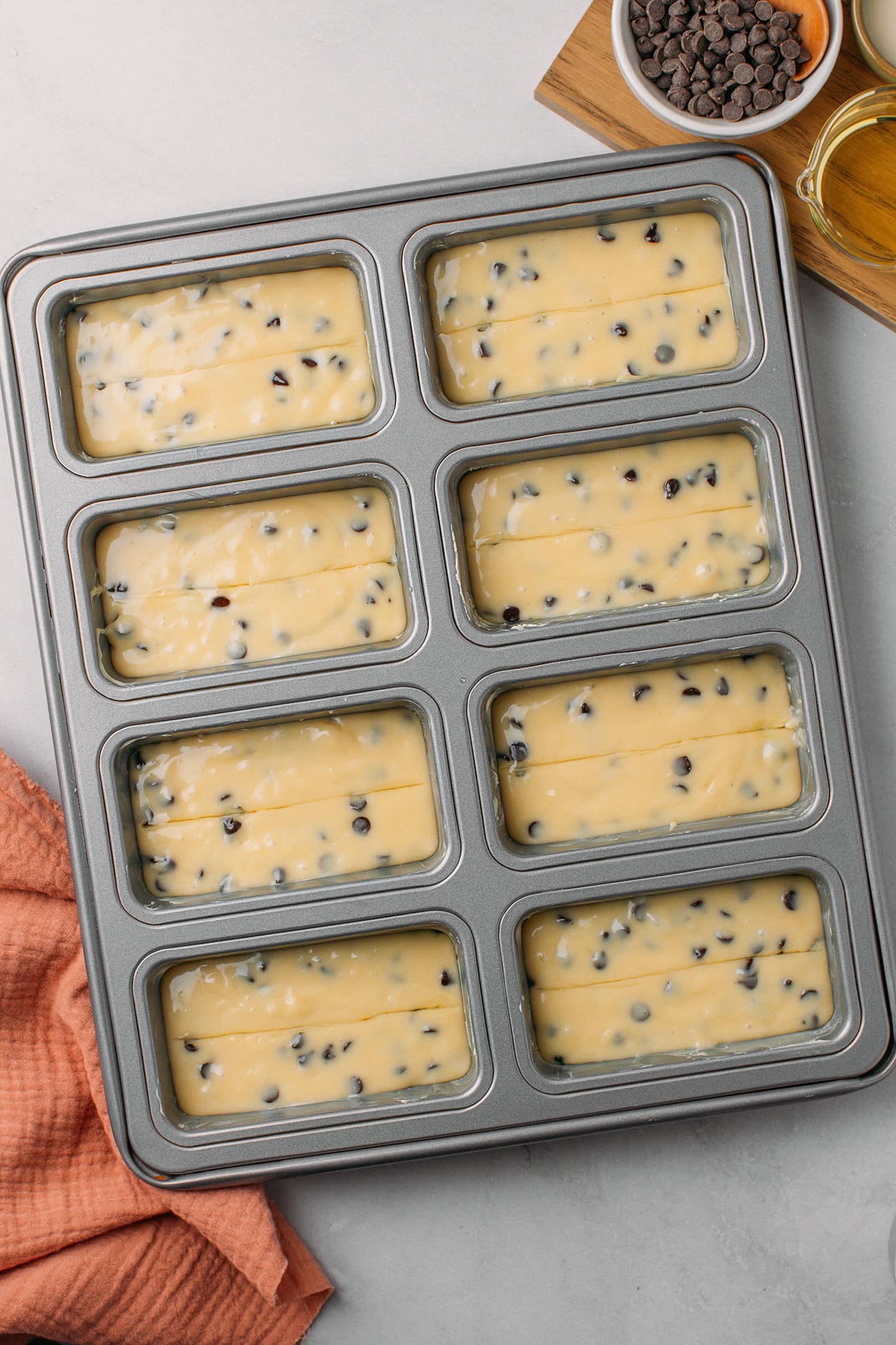 Mini loaf cake pan with 8 cavities filled with cake batter.