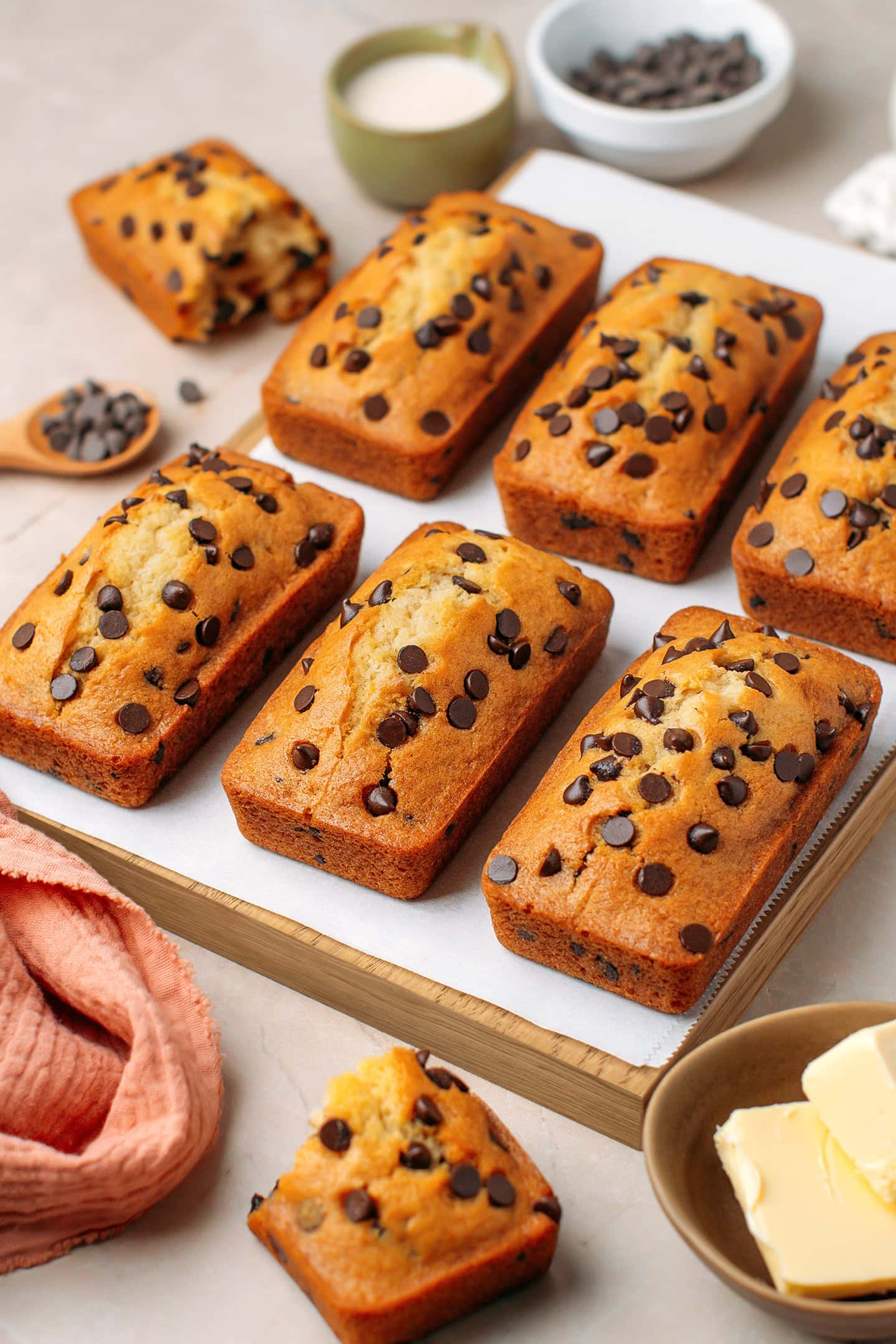 Six mini chocolate chip loaf cakes on a cutting board.