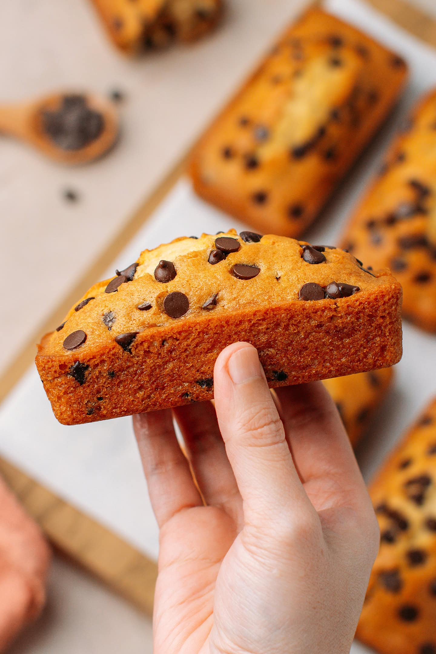 Holding a mini loaf cake topped with chocolate chips.