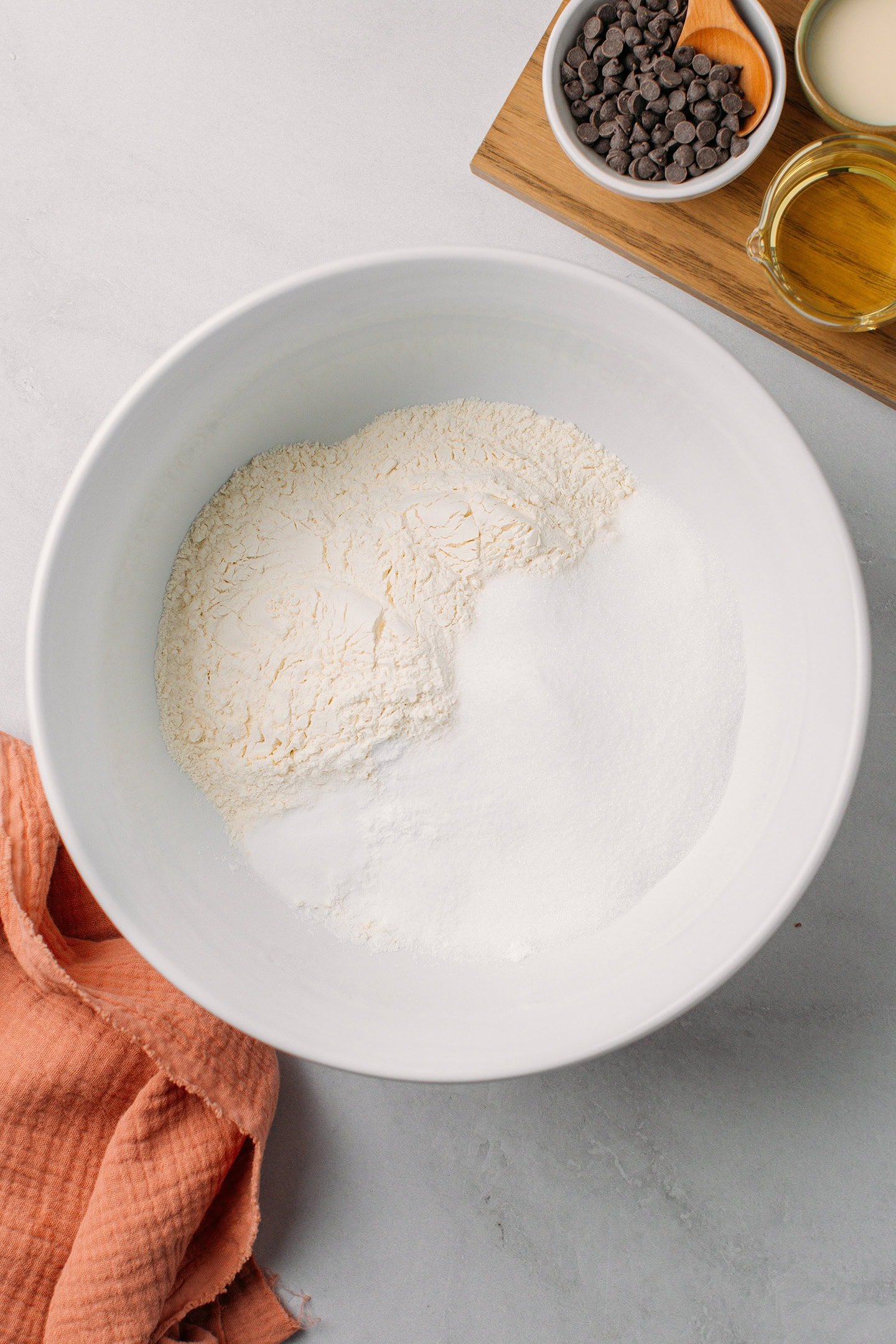 Flour, sugar, baking powder, and baking soda in a mixing bowl.