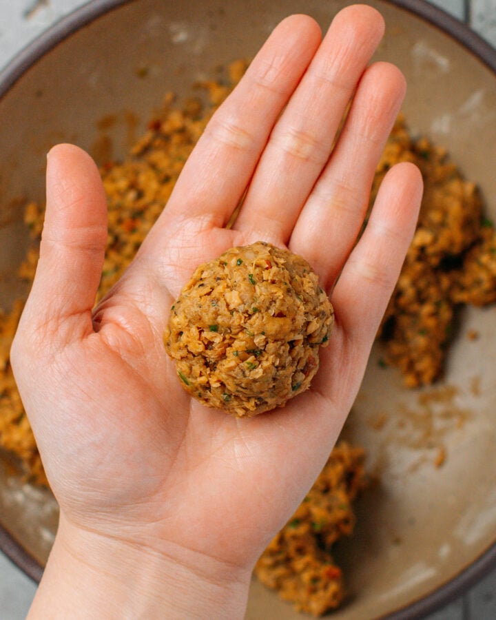 Holding a vegan meatballs.