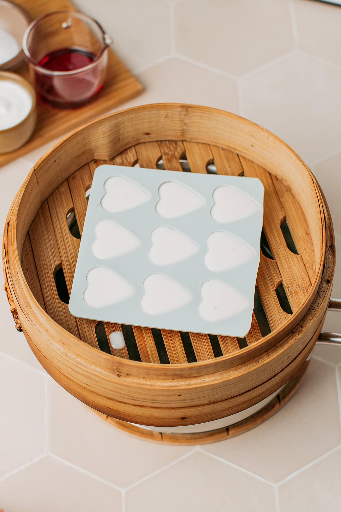 Heart-shaped silicone mold filled with homemade gummies in a bamboo steamer.