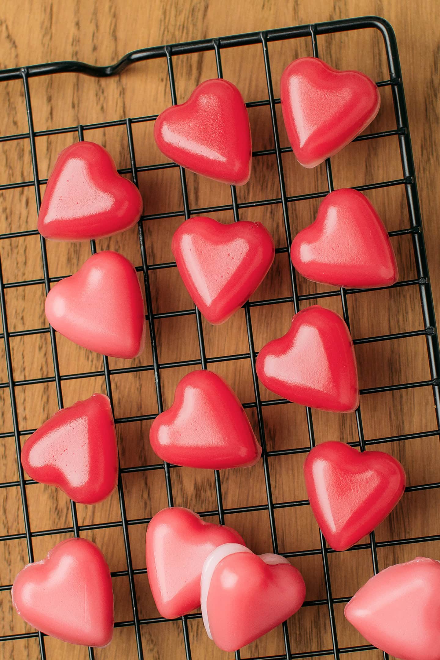 Heart-shaped gummies on a grid placed on top of a wooden board.