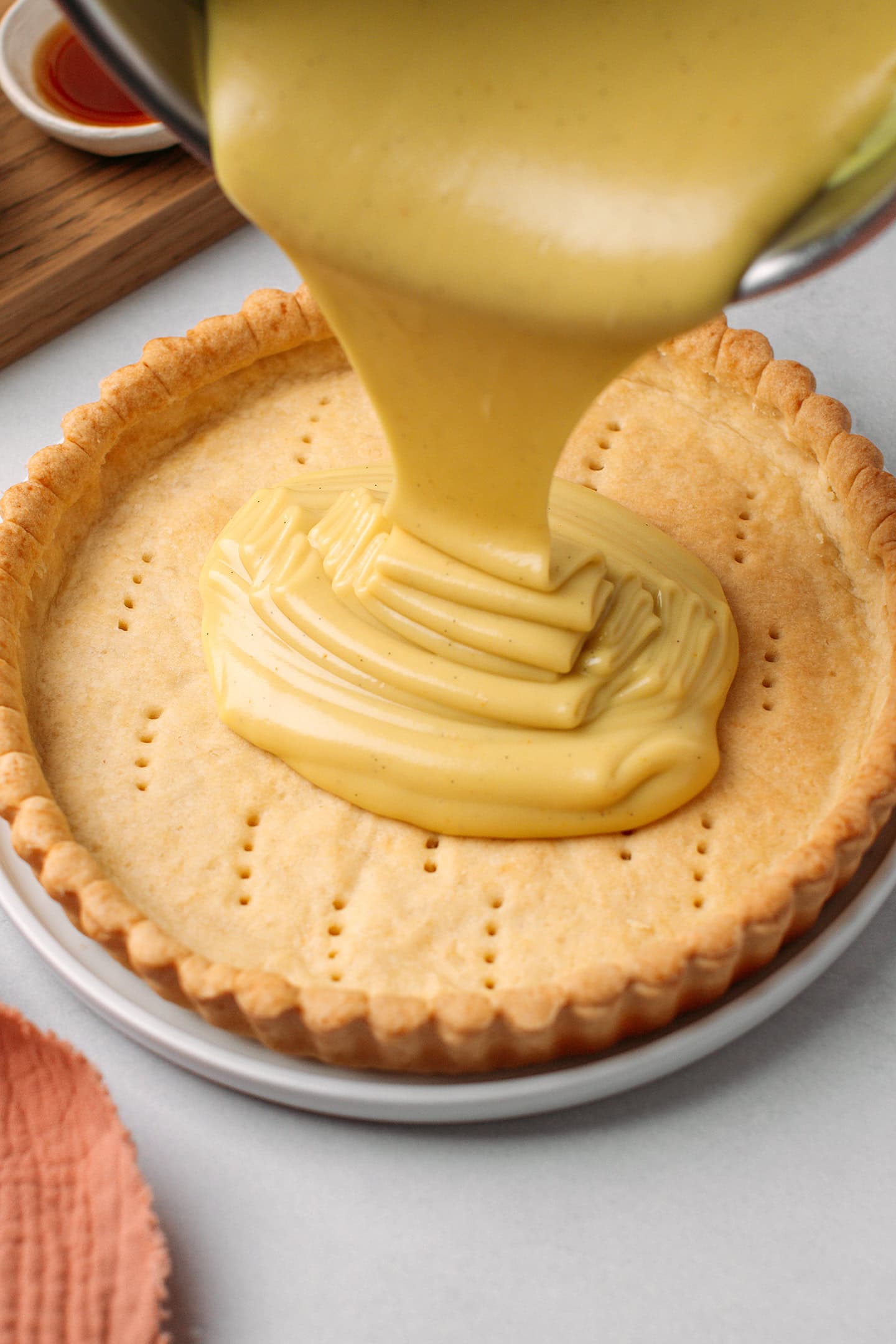 Pouring a thick custard into a baked pie crust.