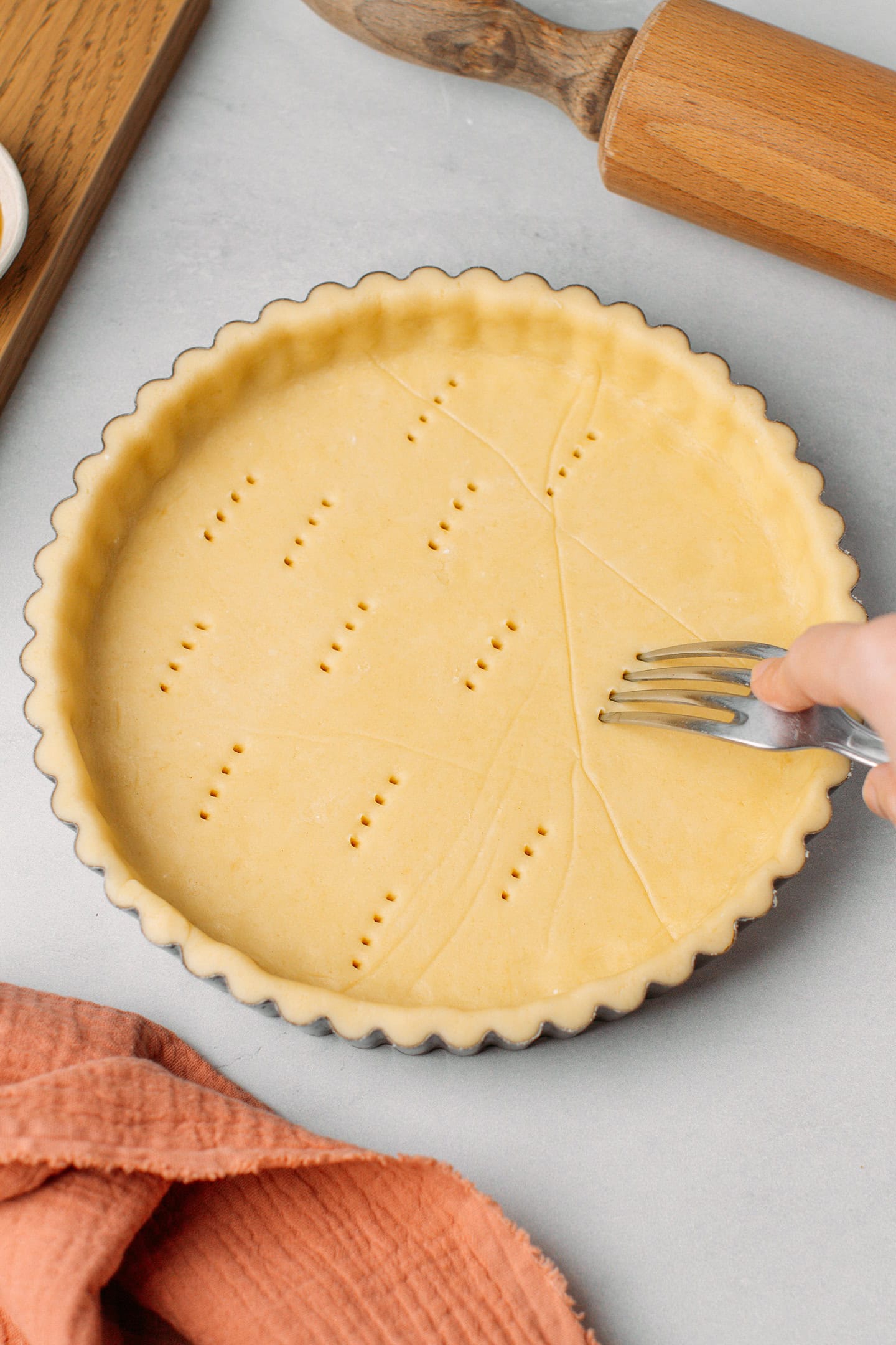 Pricking the bottom of an unbaked crust using a fork.